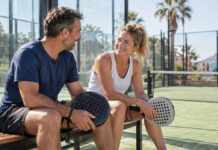 A short padel break for two: planning for different abilities A couple holding padel rackets and resting on a bench beside an outdoor court.